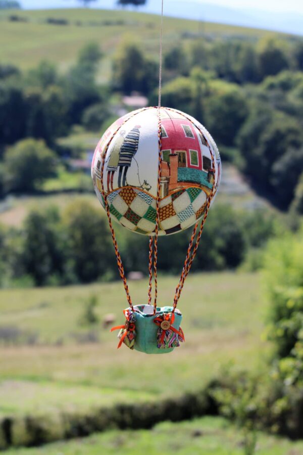 Montgolfière de décoration Promenade. Travail d'incrustation de tissus sur boule de polystyrène. Atelier à Villefranque (64)