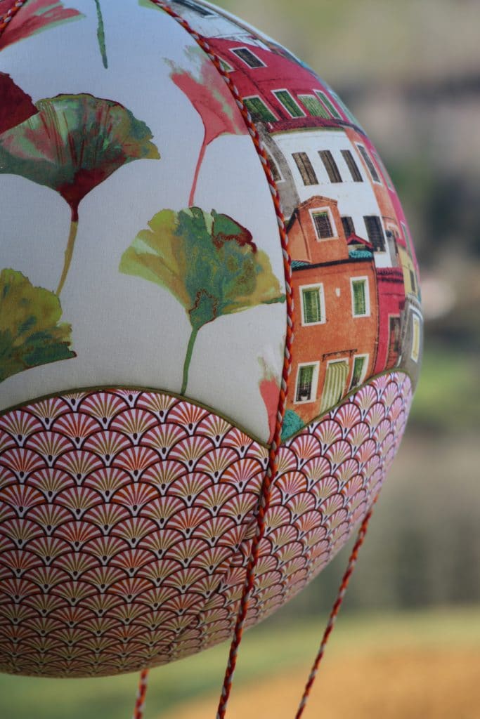 Tissus maisons et ginkgos incrustés sur une boule de polystyrène pour une montgolfière de décoration. Atelier à Villefranque (64)