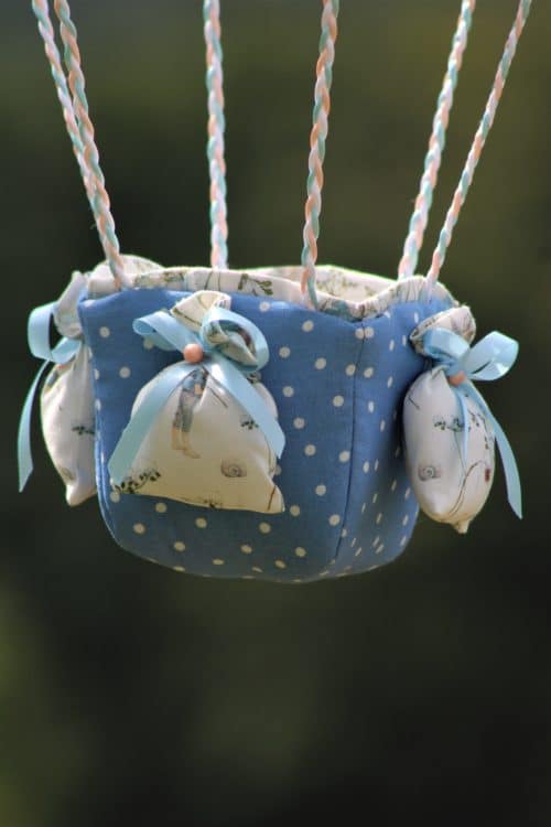 Panier en tissu orné de petits sacs "lest" pour une montgolfière de décoration. Atelier à Villefranque (64)