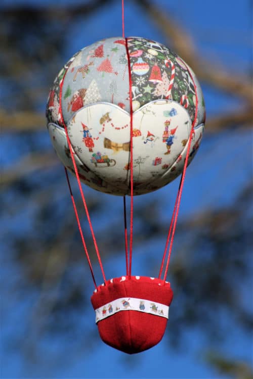 Montgolfière de décoration Au pays des lutins, sur le thème de Noël. Travail d'incrustation de tissu sur une boule de polystyrène. Atelier à Villefranque (64)