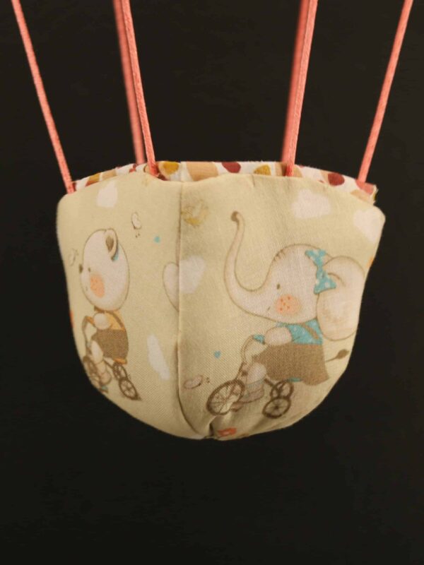 Panier en tissu imprimé éléphants et ours à vélo, pour une jolie montgolfière de décoration.