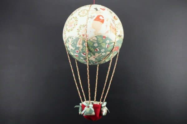 Montgolfière de décoration en tissus imprimés lapins stylisés. Travail d'incrustation sur une boule de polystyrène. Cadeau original pour un cadeau de naissance. Atelier à Villefranque (64)