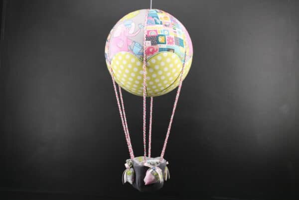 Montgolfière de décoration Eléphants roses en tissus imprimés pepsi. Travail d'incrustation sur une boule de polystyrène. Cadeau original pour un cadeau de naissance. Atelier à Villefranque (64)