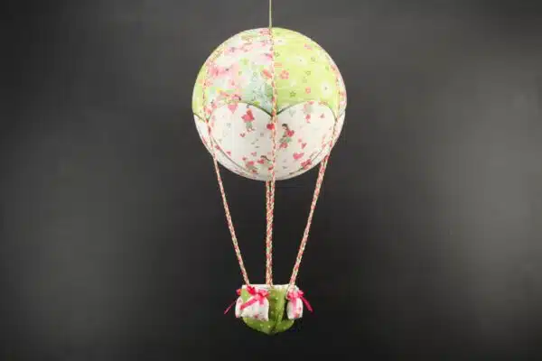 Montgolfière de décoration en tissus imprimés fleurs et petits cœurs. Travail d'incrustation sur une boule de polystyrène. Cadeau original pour un cadeau de naissance. Atelier à Villefranque (64)