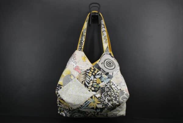 Sac en tissu Patchwork, doublé et ouatiné. Poches intérieures zippées et doublées. Un mousqueton permet d'accrocher les clefs. Atelier à Villefranque (64)