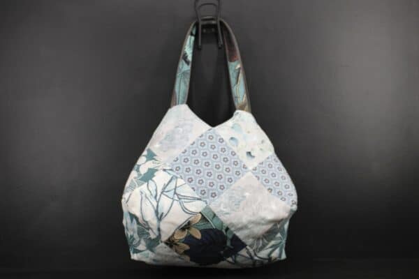 Sac en tissu Patchwork, doublé et ouatiné. Poches intérieures zippées et doublées. Un mousqueton permet d'accrocher les clefs. Atelier à Villefranque (64)