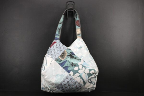 Sac en tissu Patchwork, doublé et ouatiné. Poches intérieures zippées et doublées. Un mousqueton permet d'accrocher les clefs. Atelier à Villefranque (64)