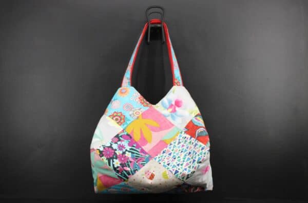 Sac en tissu Patchwork, doublé et ouatiné. Poches intérieures zippées et doublées. Un mousqueton permet d'accrocher les clefs. Atelier à Villefranque (64)