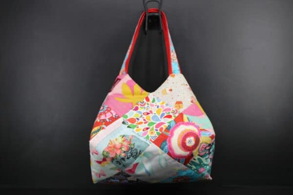 Sac en tissu Patchwork, doublé et ouatiné. Poches intérieures zippées et doublées. Un mousqueton permet d'accrocher les clefs. Atelier à Villefranque (64)