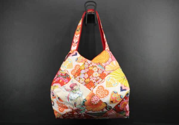 Sac en tissu Patchwork, doublé et ouatiné. Poches intérieures zippées et doublées. Un mousqueton permet d'accrocher les clefs. Atelier à Villefranque (64)