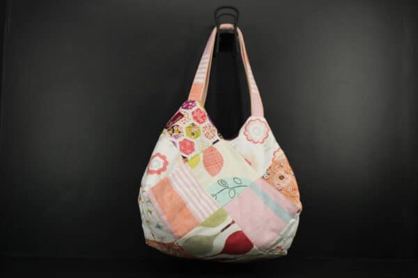 Sac en tissu Patchwork, doublé et ouatiné. Poches intérieures zippées et doublées. Un mousqueton permet d'accrocher les clefs. Atelier à Villefranque (64)