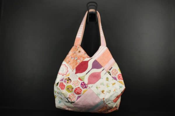 Sac en tissu Patchwork, doublé et ouatiné. Poches intérieures zippées et doublées. Un mousqueton permet d'accrocher les clefs. Atelier à Villefranque (64)
