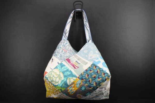 Sac en tissu Patchwork, doublé et ouatiné. Poches intérieures zippées et doublées. Un mousqueton permet d'accrocher les clefs. Atelier à Villefranque (64)