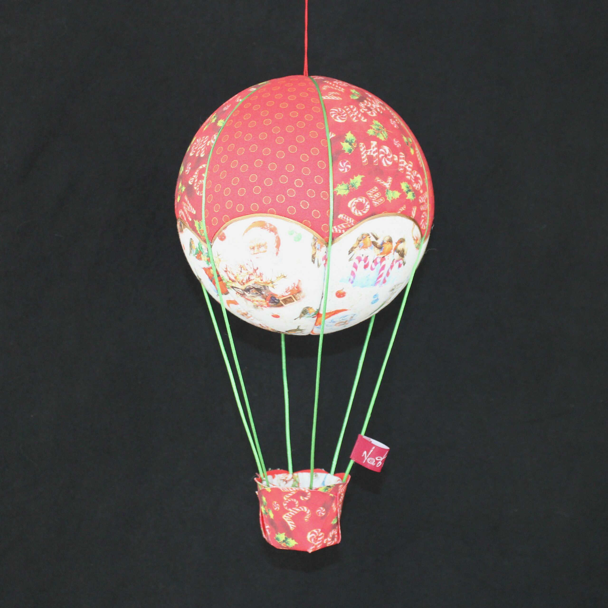 Montgolfière Nat'Fantaisies, en tissus imprimés sur le thème de Noël. Idéal près du sapin ou dans l'entrée. Travail d'incrustation sur une boule de polystyrène. Atelier dans les Pyrénées Atlantiques (64)